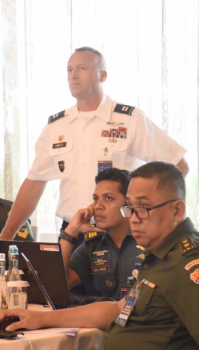 Hawaii Army National Guard Capt. John Conley, Tentara Nasional Indonesia Navy Capt. Gilang Chrisnamurti, and TNI Army Maj. Sakundira Parama, listen to presentations during the 2019 Information System and Technology Exchange, July 23, 2019, Jakarta, Indonesia. This year’s third annual ISTX falls under the Hawaii National Guard’s State Partnership Program, and aims to share best practices, assist in cyber security doctrine development, and enhance the cyber security capabilities to effectively defend and protect critical cyber information infrastructure from malicious virus and cyber intrusion. (U.S. Army National Guard Photo by Staff Sgt. Katie Gray)
