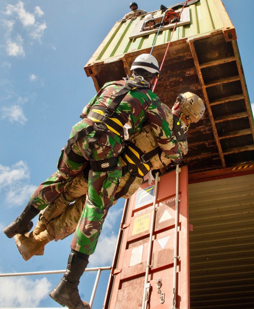 An Indonesian soldier assists a simulated wounded Hawaii Army National Guardsman as he repels from a second story building during a Combined - Multinational Task Force [CTF 501] search and extraction training scenario on July 18, 2019 at Kalaeloa Urban Search and Rescue Training area, Hawaii. Service members from the Philippines, Indonesia, Bangladesh, Vietnam, Oregon Air National Guard traveled to Hawaii as part of a State Partnership Program training event. The CTF 501 aims to increase the amount of trained individuals postured to provide expeditionary response throughout the Asian-Pacific region. (U.S. Air National Guard photo by Master Sgt. Mysti Bicoy)