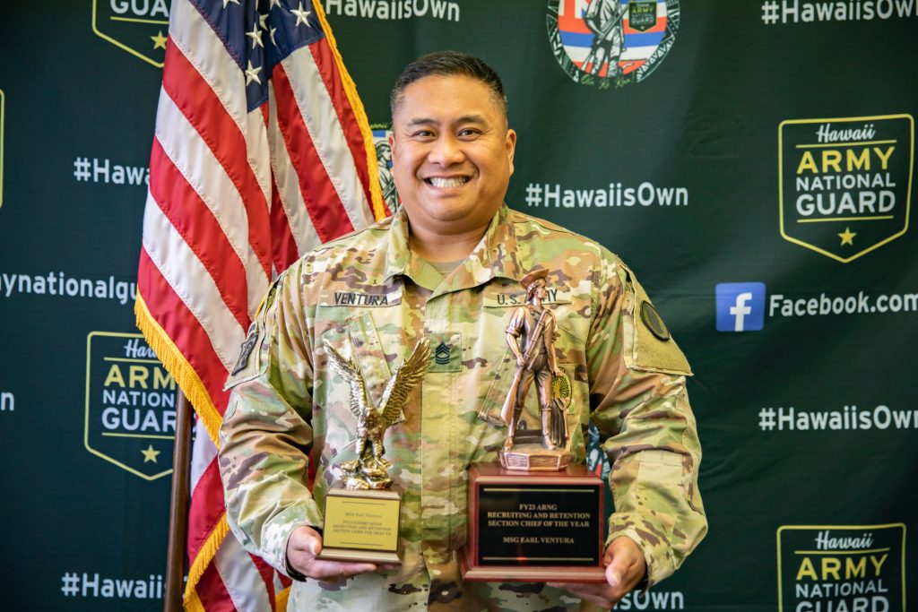 U.S. Army Master Sgt. Earl Ventura, a recruiting and retention section chief assigned to the Recruiting and Retention Battalion, Hawai‘i Army National Guard, poses with the FY 23 Expert Seven Recruiting and Retention Section Chief for Strength Maintenance Advisory Group VII and FY 23 Recruiting and Retention Section Chief of the Year awards at Honolulu, Hawai‘i, April 2, 2024. Ventura was awarded as the top Army National Guard Recruiting and Retention NCOIC from all 54 states and territories. (U.S. Army National Guard photo by Sgt. Lianne M. Hirano