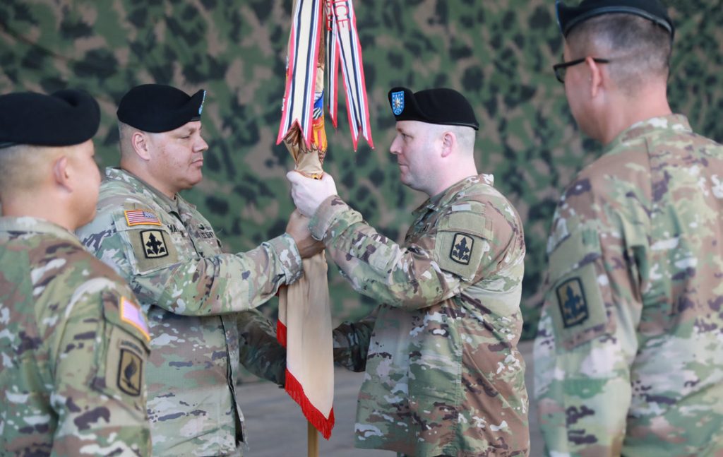 U.S. Army Col. David R. Hatcher II, left, commander of the 29th Infantry Brigade Combat Team (IBCT), Hawaii Army National Guard, passes the unit colors to the incoming commander, Lt. Col. Joshua A. Jacobs, right, of the 29th Brigade Support Battalion (BSB), 29th IBCT, during the 29th BSB change of command ceremony in Kapolei, Hawaii, Jan. 6, 2024. The change of command ceremony is a time-honored tradition within the Army which commemorates the relinquishment of command by passing the unit colors from the outgoing commanding officer to the incoming commanding officer. (U.S. Army National Guard photo by Spc. Bethany Cravalho