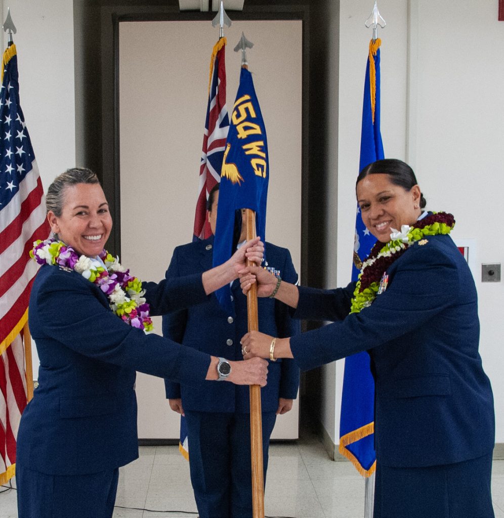 U.S. Air Force Col. Amy Arfman, 154th Mission Support Squadron commander, presents the guidon to Maj. Allison Delos Santos, 154th Security Forces Squadron commander, Dec. 1, 2023 at Joint Base Pearl Harbor-Hickam, Hawaii. Delos Santos became the first female commander of the 154th SFS. (U.S. Air National Guard photo by Airman 1st Class Roann Gatdula)