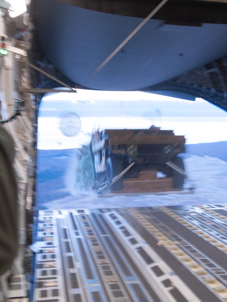 A U.S. Army Humvee and additional supplies assigned to the 2nd Brigade, 11th (Airborne) Division are offloaded from a U.S. Air Force C-17 Globemaster III over Anchorage, Alaska as part of a training exercise for the Joint Pacific Multinational Readiness Center Nov. 2, 2023. JPMRC includes live, virtual, and constructive training components, which generate a realistic and challenging experience for all participants. JPMRC replicates some of the most difficult aspects of military operations and provides unparalleled value. (U.S. Air National Guard photo by Airman 1st Class Roann Gatdula)