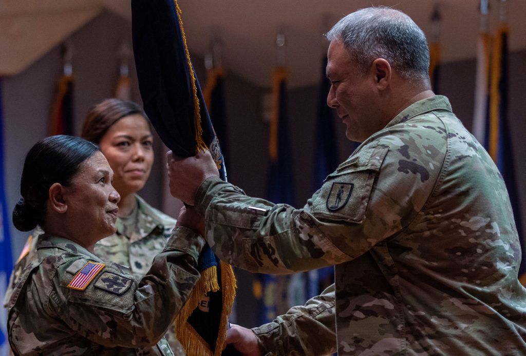 U.S. Army Lt. Col. Normandy F. Smithers, the incoming commander of 2nd Battalion, 298th Regiment Multi-functional Regional Training Institute (RTI), Hawaii Army National Guard (HIARNG), passes the unit guidon to Master Sgt. Gloria Agron, the Senior Enlisted Soldier at 2nd Battalion, 298th RTI, HIARNG, during the change of command ceremony in Waimanalo, Hawaii, Jan. 7, 2024. The change of command ceremony is a time-honored tradition within the Army which commemorates the relinquishment of responsibility by passing the unit’s colors from one officer to another. (U.S. Army National Guard photo by Spc. Sean Walker)