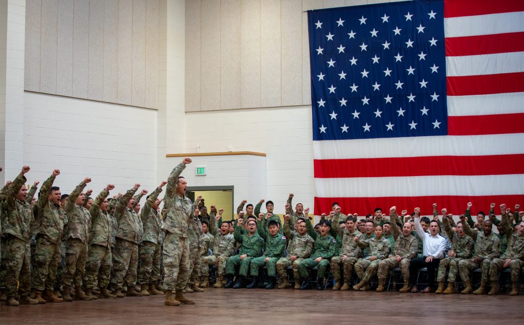 U.S. Soldiers and soldiers of the Singapore Armed Forces cheer together during the opening ceremony for Exercise Tiger Balm 2024 at Joint Base Lewis-McChord, May 6, 2024. Bilateral exercises such as Tiger Balm increase interoperability with our Singapore partners through shared experiences and tough realistic training. (U.S. Army National Guard photo by Cpl. Casandra B. Ancheta)