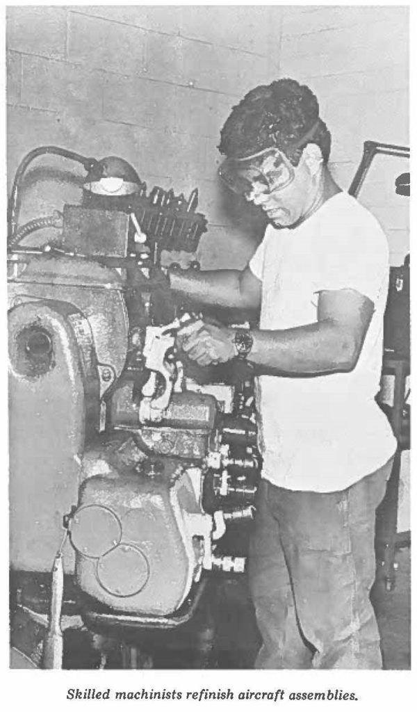 Skilled machinists refinish aircraft assemblies.
