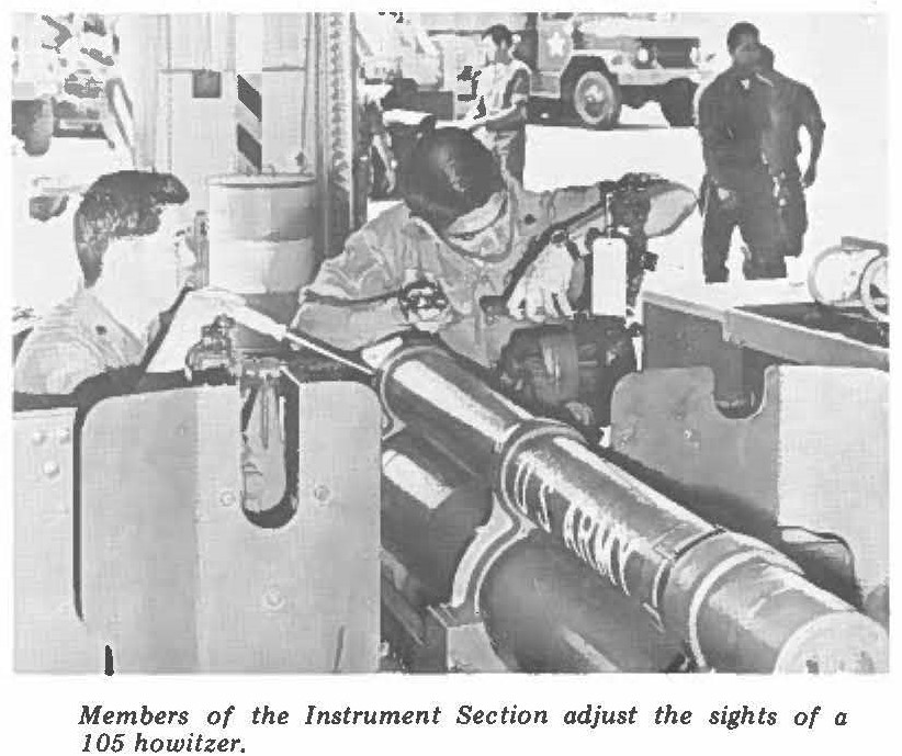 Members of the Instrument Section adjust the sights of a 105 howitzer.