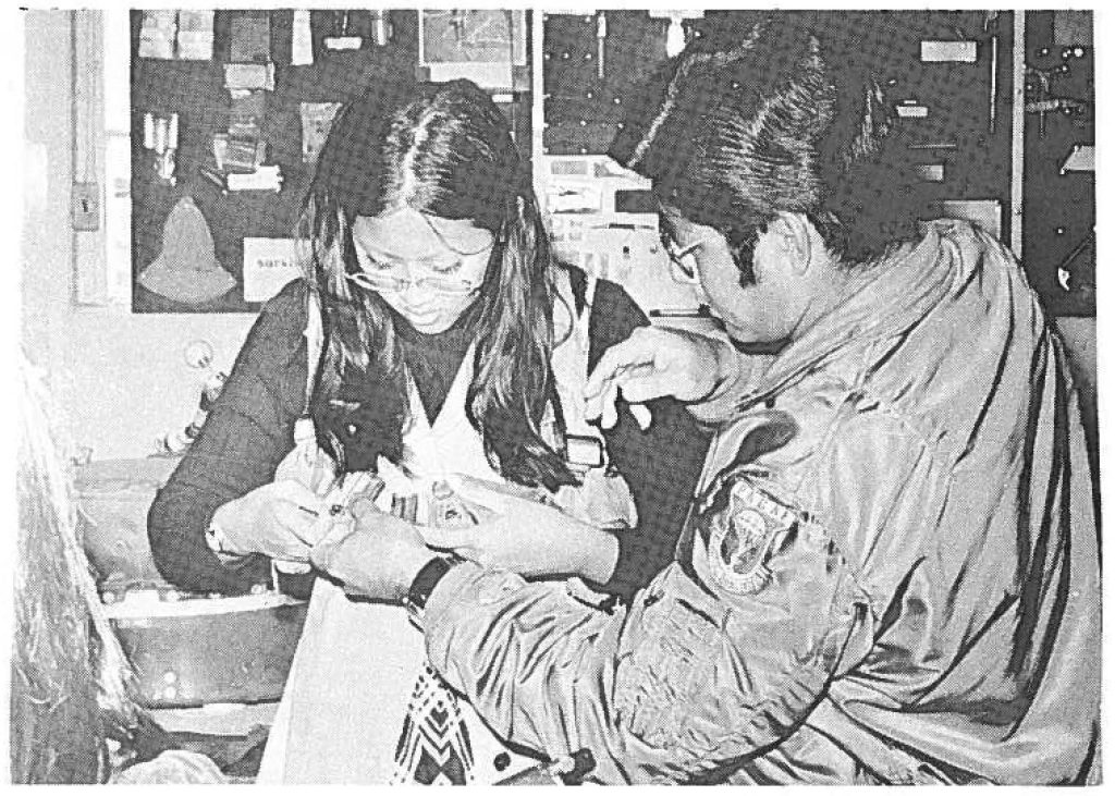 TSGT Howard Hironaka fits one of the students with the "Mae West" life vest.
