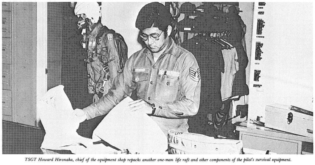 TSGT Howard Hironaka, chief of the equipment shop repacks another one-man life raft and other components of the pilot's survival equipment.