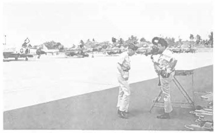 A FILM CREW, working under the direction of Major James Elliott (left), Public Affairs Officer for the National Guard Bureau, are pictured on 154th Fighter Group flight line preparing to take pictures of departing Ohio F-84 jets. Photographer, Major Ray Simek of Chicago (right) and Major Frank Hirons (not pictured) also photographed 169th AC&W squadron operations at Wheeler and Mount Koala during April visit to Hawaii. Also to be featured in the next NGB produced movie will be the men of the 1st Battalion, 299th Infantry, photographed at Kahuku during weekend maneuvers.