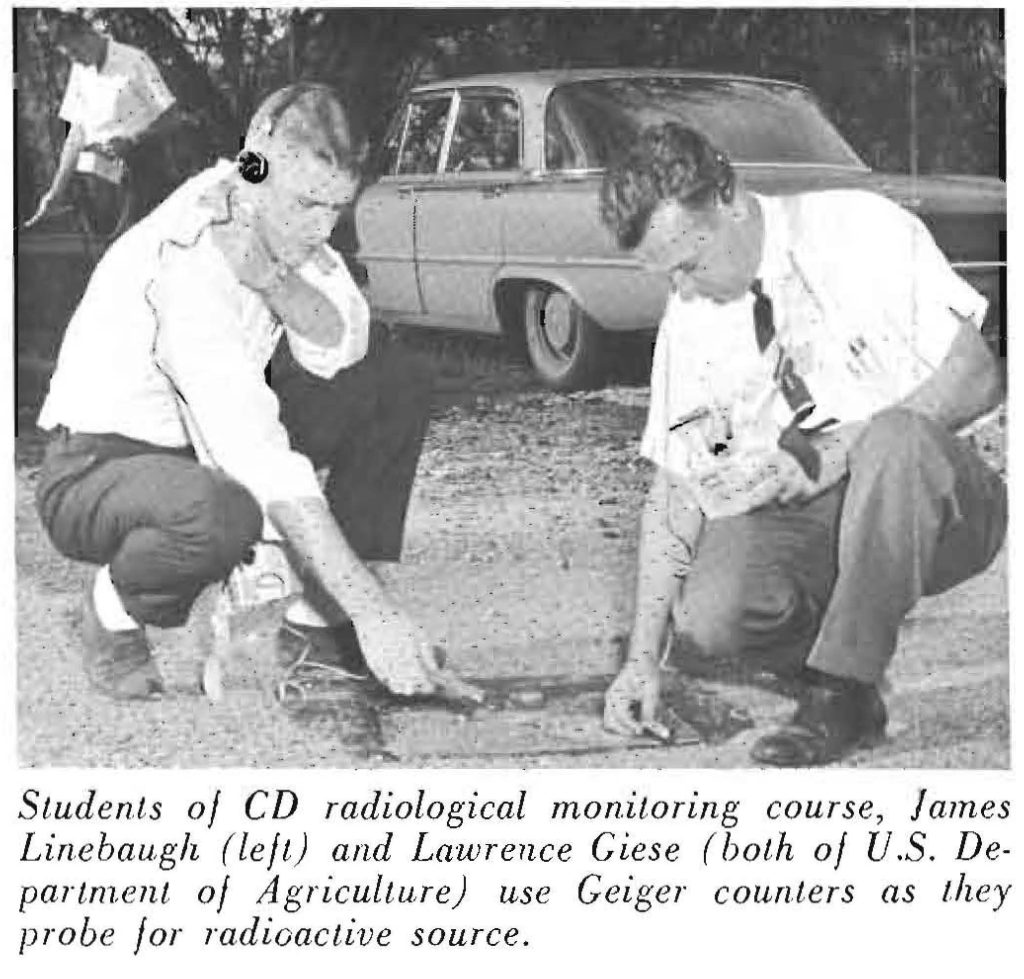 Students of CD radiological monitoring course, James Linebaugh (left) and Lawrence Giese (both of u.s. Department of Agriculture) use Geiger counters as they probe for radioactive source.