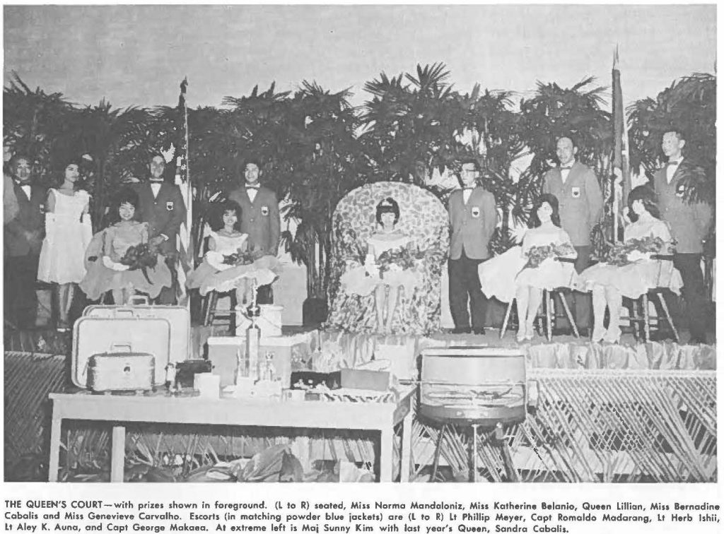 THE QUEEN'S COURT - with prizes shown in foreground. (L to R) seated, Miss Norma Mandaloniz, Miss Katherine Belanio, Queen Lillian, Miss Bernadine Cabahs and Mm Genevieve Carvalho. Escorts (in matching powder blue jackets) are (L to R) Lt Phillip Meyer, Capt Romaldo Madarang, lt Herb Ishii, lt Aley K. Auna, and Capt George Makaea. At extreme left is Maj Sunny Kim with last year's Queen, Sandro Cobalis.