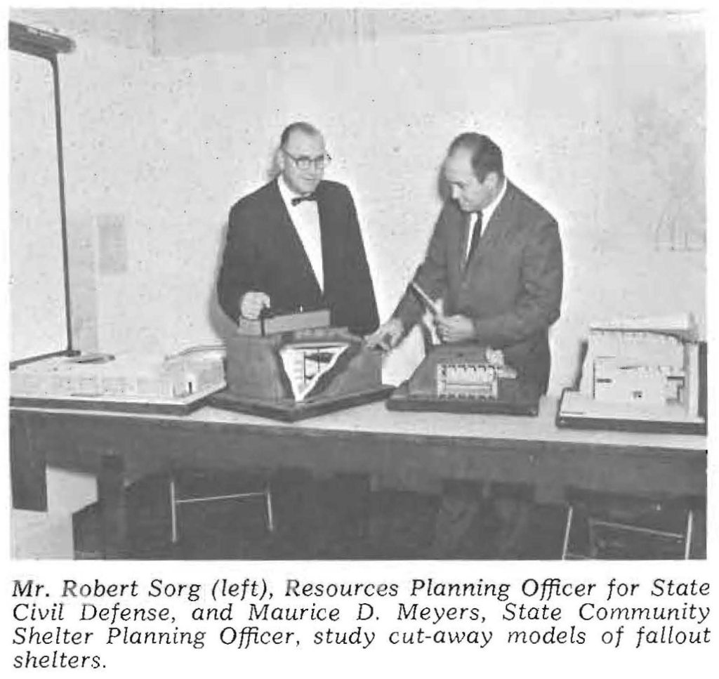 Mr. Robert Sorg (left), Resources Planning Officer for State Civil Defense, and Maurice D. Meyers, State Community Shelter Planning Officer, study cut-away models of fallout shelters