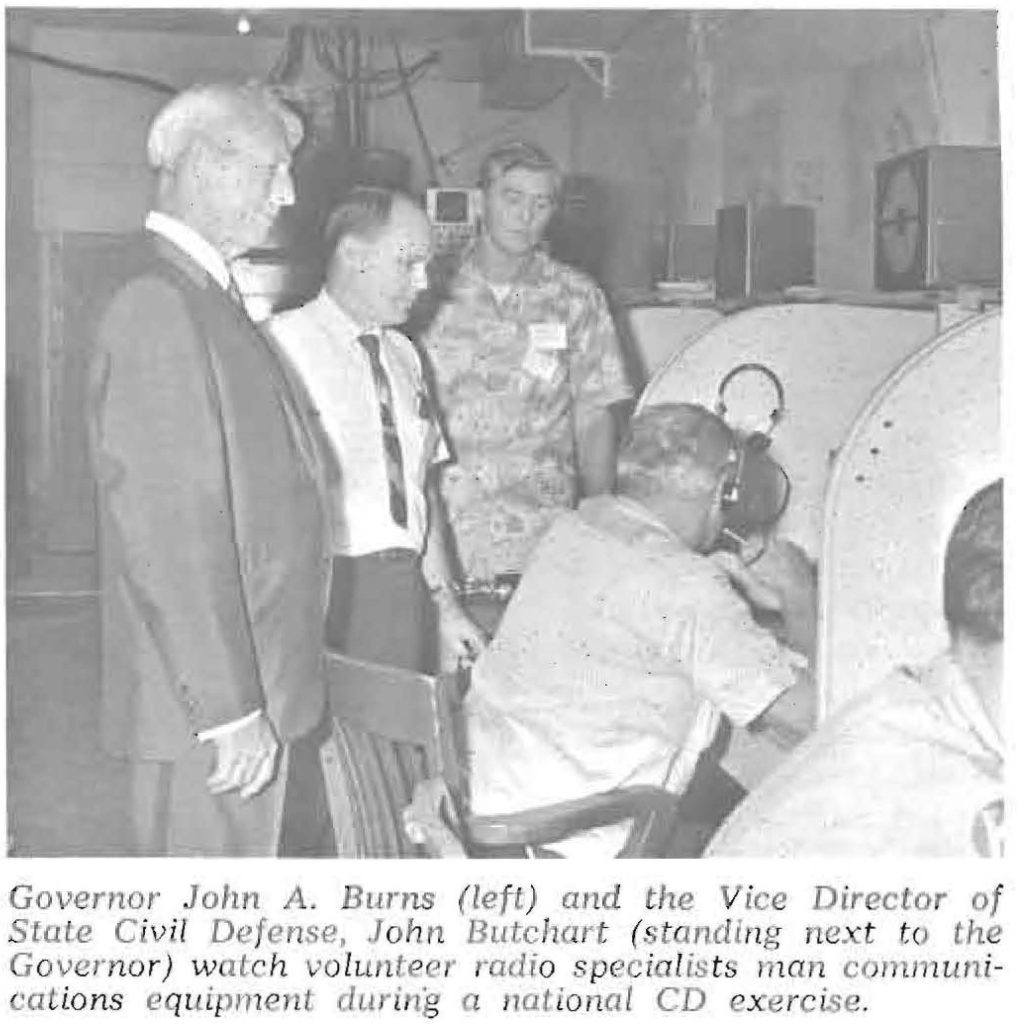 Governor John A. Burns (left) and the Vice Director of State Civil Defense, John Butchart (standing next to the Governor) watch volunteer radio specialists man communications equipment during a national CD exercise.