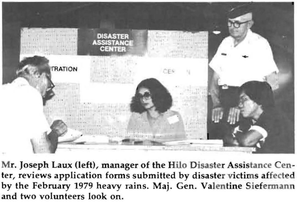 Mr. Joseph Laux (left), manager of the Hilo Disaster Assistance Center, reviews application forms submitted by disaster victims affected by the February 1979 heavy rains. Maj. Gen. Valentine Siefermann and two volunteers look on.