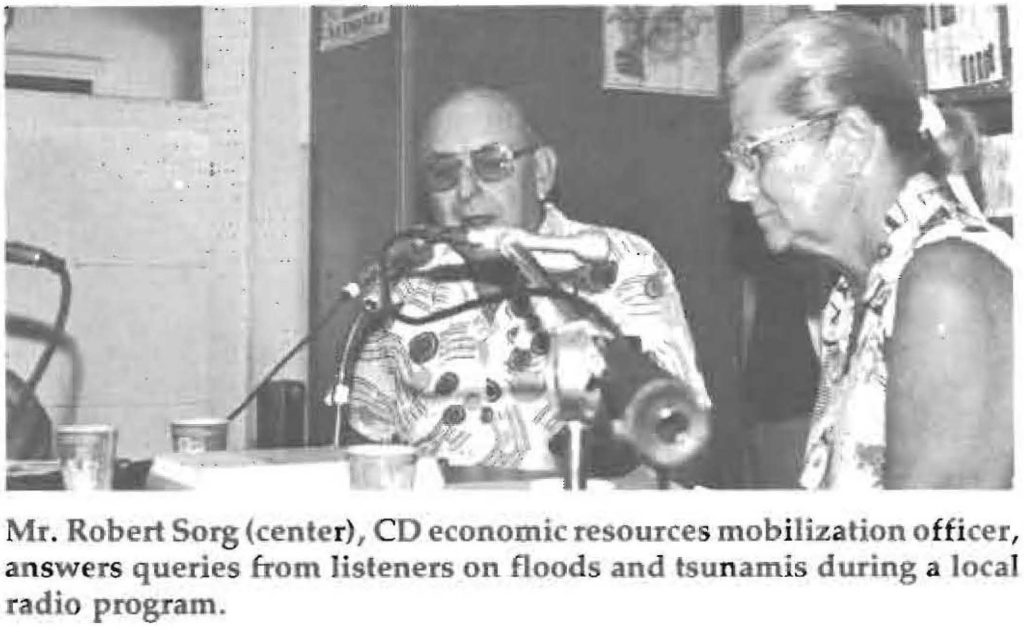 Mr. Robert Sorg (center), CD economic resources mobilization officer, answers queries from listeners on floods and tsunamis during a local radio program.