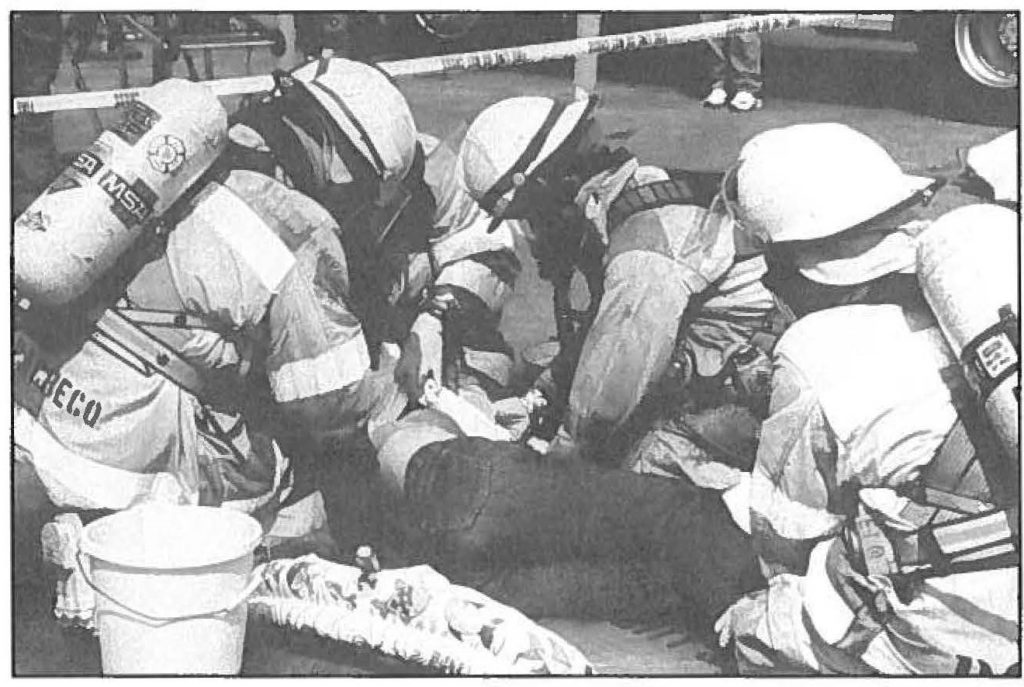 1ST CLASS TREATMENT -- Local firefighters tend to person who has succumb to an unknown hazardous agent at HAZMAT Exercise '95. -Ron Matsumura photo