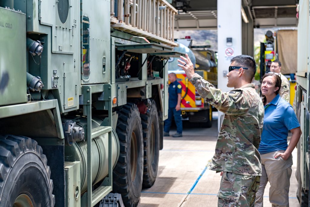 Following a red flag warning of increased fire risk, the Hawaiʻi Army National Guard (HIARNG), staged in support of the Honolulu Fire Department with ground assets in a first-time collaboration for community safety. Soldiers assigned to the 297th Engineer Detachment Firefighting Team, 103rd Troop Command, HIARNG, went to Fire Station 28 in Nanakuli, Hawaiʻi with their M1158 Heavy Expanded Mobility Tactical Truck-based water tender on Aug. 1, 2025. During the visit Staff Sgt. John Segawa, a station chief assigned to the 297th ENG DET, explained his equipment and capabilities including the water tender which holds 3,000 gallons. Above, fire crews from Nānākuli, Makakilo and the HIARNG meet with Dori Booth, the new State Fire Marshal and Maj. Gen. Stephen F. Logan, Adjutant General for the State of Hawaiʻi, to discuss the importance of interoperability amongst fire crews. – Hawai‘i Army National Guard photos by Staff Sgt. John Schoebel