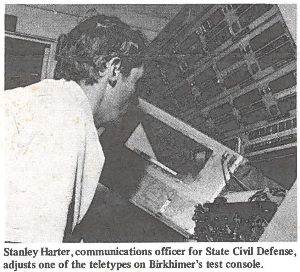 Stanley Harter, communications officer for State Civil Defense, adjusts one of the teletypes on Birkhimer's test console.