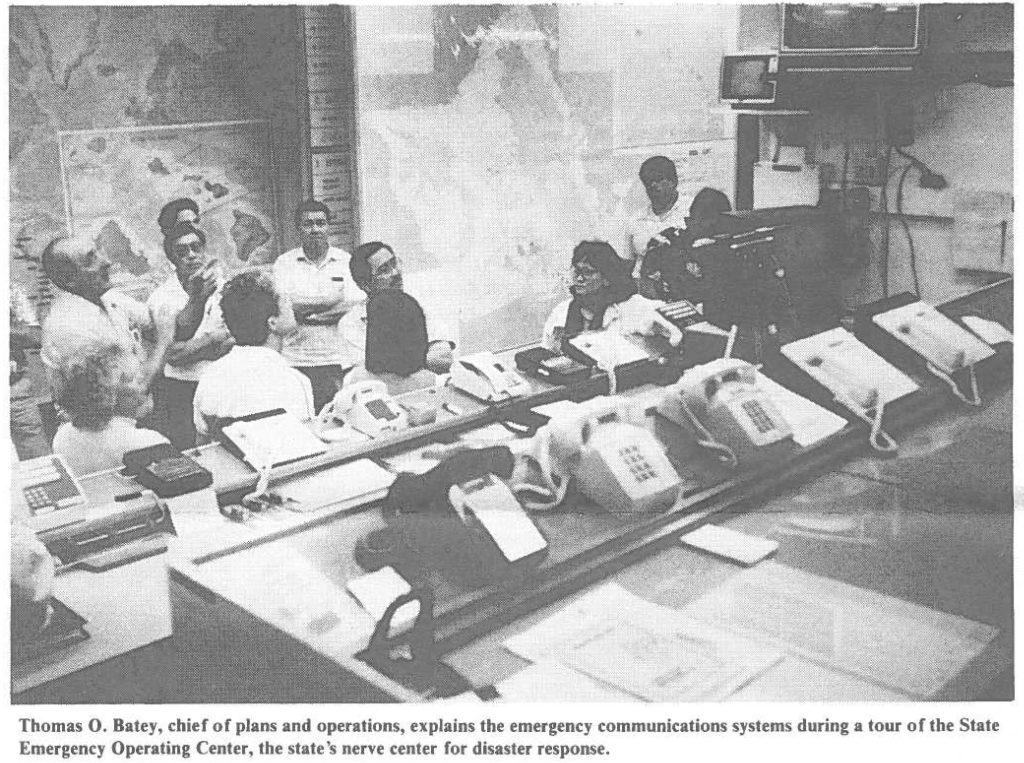 Thomas 0. Batey, chief of plans and operations, explains the emergency communications systems during a tour of the State Emergency Operating Center, the state's nerve center for disaster response