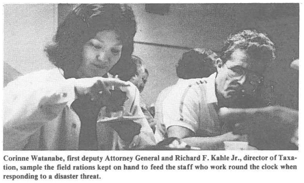 Corinne Watanabe, first deputy Attorney General and Richard F. Kahle Jr., diredor or Taxation, sample the field rations kept on hand to reed the staff who work round the clock when responding to a disaster threat.