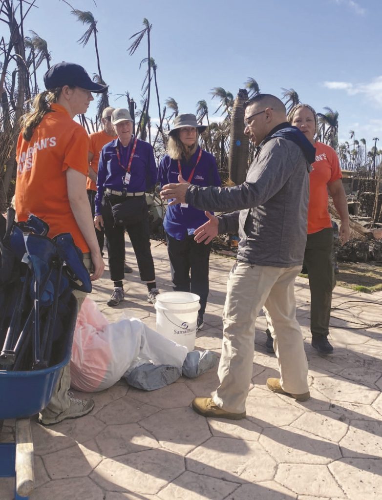 HI-EMA Administrator Col. (Ret) James Barros greets members of Samaritan’s Purse, a religious organization which assisted residences in sifting through debris following the Aug. 8, 2023 wildfire in Lahaina. – Ethann Oki photo