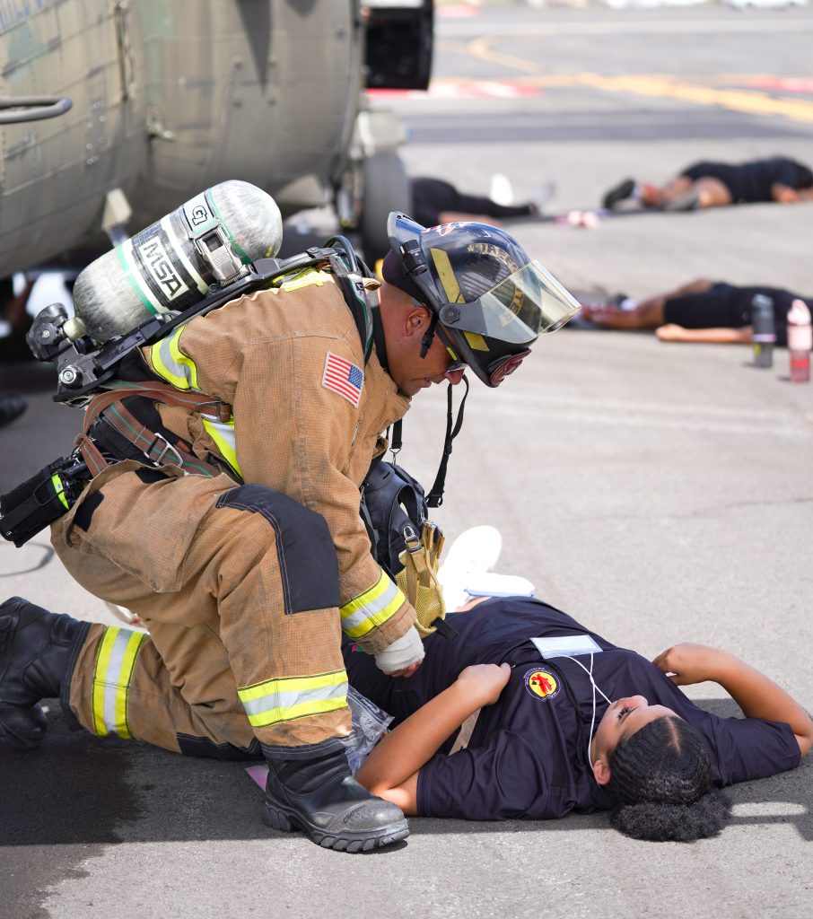 JCA associate Trinity Pyne-Williams are assisted by fire department personnel during the 2025 Hilo International Airport Triennial Exercise. – Hawai‘i Job Challenge Academy photo