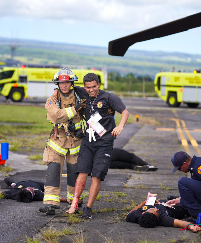 JCA associates Kalanikupule De Cambra are assisted by fire department personnel during the 2025 Hilo International Airport Triennial Exercise. – Hawai‘i Job Challenge Academy photo