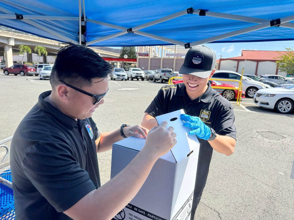 Sgt. Ryan Cardenas, left, and Sgt. Mark Sulpico prepared collection boxes during the National Take-Back Initiative event at the Kahala Times Supermarket collection site.