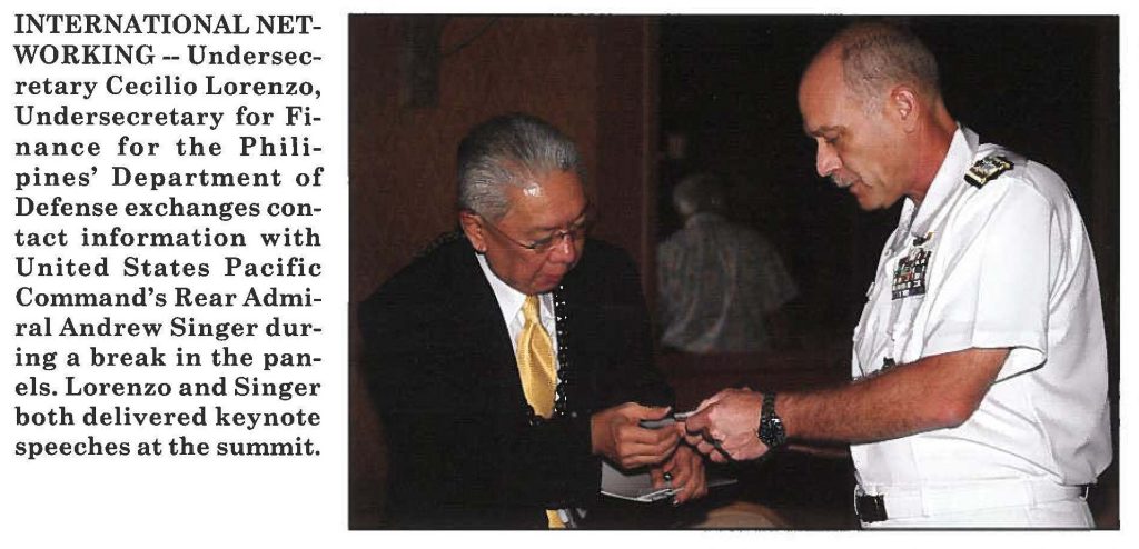 INTERNATIONAL NETWORKING -- Undersecretary Cecilio Lorenzo, Undersecretary for Finance for the Philipines' Department of Defense exchanges contact information with United States Pacific Command's Rear Admiral Andrew Singer during a break in the panels. Lorenzo and Singer both delivered keynote speeches at the summit.