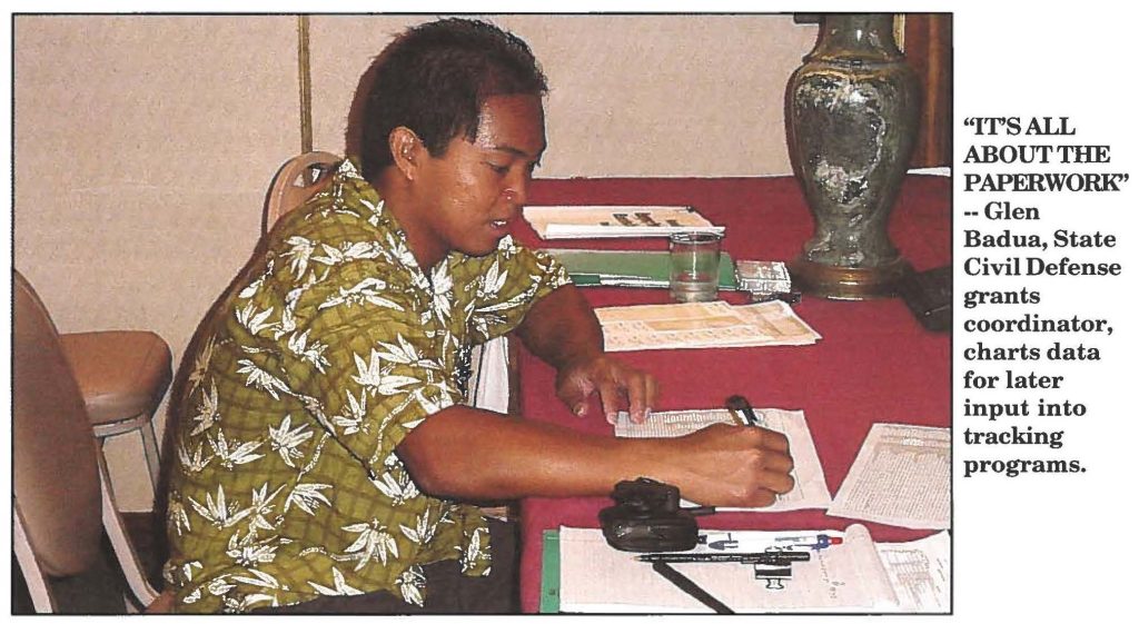 "IT'S ALL ABOUT THE PAPERWORK'' --Glen Badua, State Civil Defense grants coordinator, charts data for later input into tracking programs.