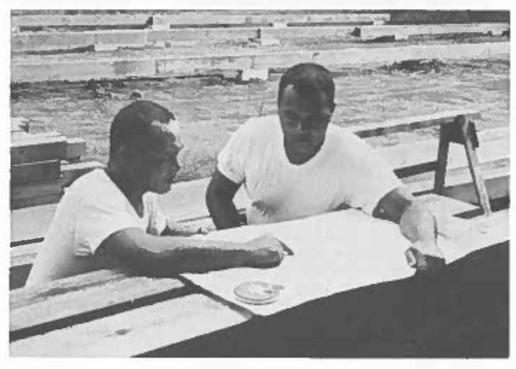 GOVERNMENT ACCOUNTING OFFICE (GAO) PLEAS-E NOTE: Battery "B" 1st Missile Battalion, needed a motor pool shed in which they could adequately perform maintenance on assigned vehicles. Because no money was available lo construct facilities, unit personnel decided they would build it themselves. Plans, which received OK from Guard and USARHAW, were drawn by PFC Pedro lemasa (fulltime Asst. IFC Operator) and "scouts" scattered in all directions lo scrounge needed materials. Right photo shows SP4 William Asinsen, fulltime wheel vehicle mechanic in charge of project (left) and Pvt Grand l. Hussey, launcher helper who did early foundation work. Thirteen other HNG'men assisted on project during spare time. Shed, located inside fence of launcher Administrative area, was started in August and should be complete in December with pouring of concrete floor.