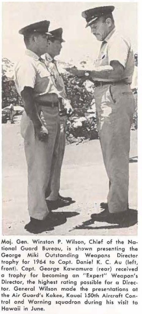 Maj. Gen. Winston P. Wilson, Chief of the Notional Guard Bureau, is shown presenting the George Miki Outstanding Weapons Director trophy for 1964 to Capt. Daniel K. C. Au (left, front). Capt. George Kawamuro (rear) received a trophy for becoming an "Expert" Weapon's Director, the highest rating possible for a Director. General Wilson mode the prestation at the Air Guard's Kokee, Kauai 150th Aircraft Control and Warning squadron during his visit to Hawaii in June.