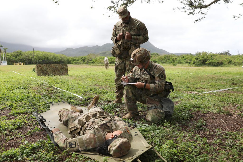 Pfc. Kendall Saxton, a firefighter with the 297th Engineer Detachment, 103rd Troop Command, HIARNG, provided care under fire and moved a casualty during the competition on March 6. U.S. Army National Guard photo by Spc. Daniel Barcenas