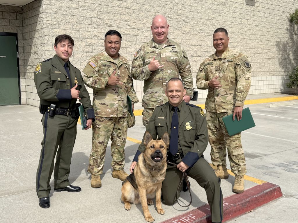 Hawaiʻi Army National Guardsmen Sgt. Mariano Vergado-Duclayan, second from left, Chief Warrant Officer 4 Jeff Hebert and Chief Warrant Officer 2 Jerome Ledward flashed shakas alongside San Diego Sector Chief Patrol Agent Justin De La Torre, far left, and Border Patrol Agent Benjamin Camacho and his canine, Boo. (U.S. Army National Guard photo by Col. Byron Cadiz)