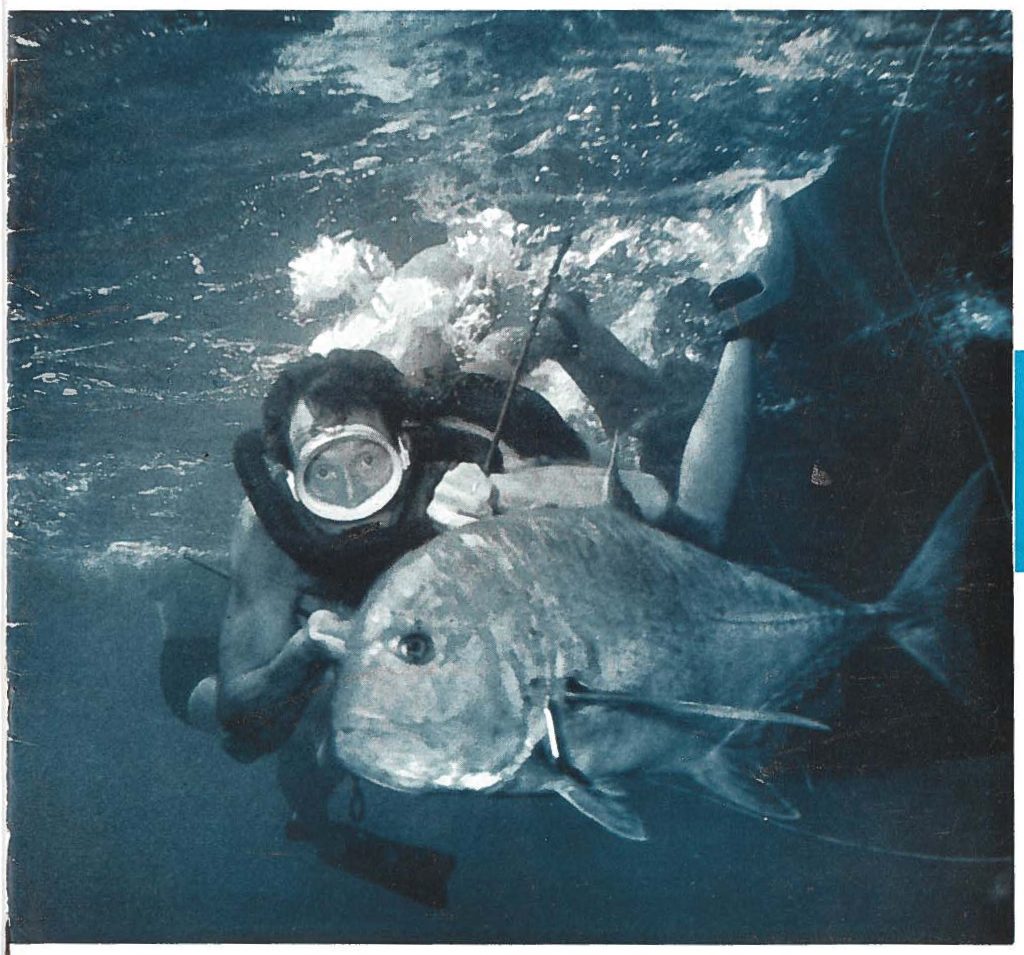 Mr. Dan Wallace, pictured with 66 pound Ulua, is one of the leaders in the SCUBA diving art. Mr. Wallace was highly instrumental in the early promotion of Self Contained Underwater Breathing Apparatus in Hawaii and has done much to promote underwater photography in the islands. This cover picture was supplied through the courtesy of Mr. Wallace.