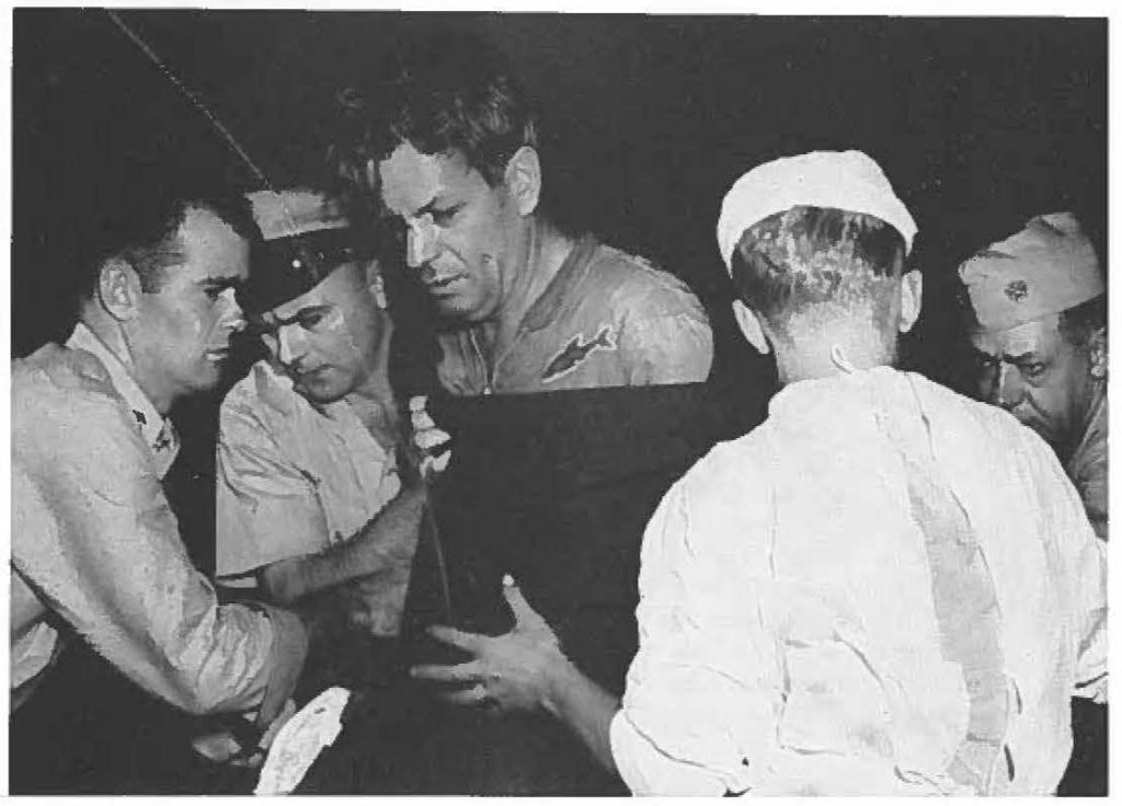 Cmdr Guy Howard of Early Warning Squadron, Barbel'S Point, is helped ashore by rescuers after spending 10 hours in the ocean after crash. Air National Guard operation was responsible for rescue of Howard and three crewmen.
