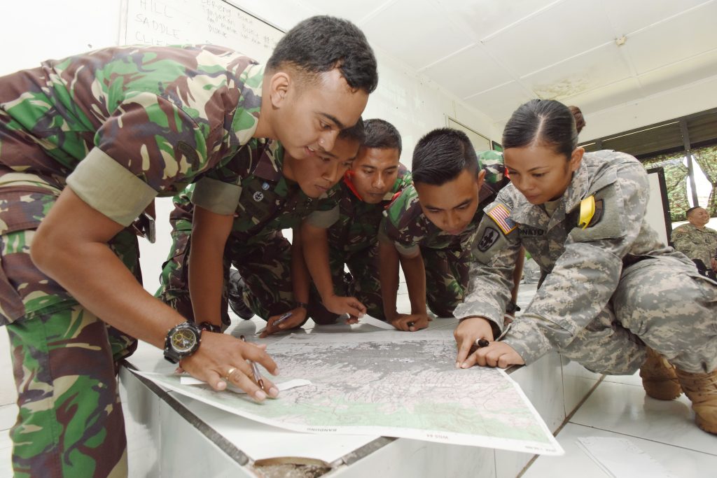 U.S. Army Sgt. 1st Class Hazel Donato, a member of the Hawaii Army National Guard, asks Soldiers from the Indonesia Army to find the distance between two points on a military map during the Non-commissioned Officer Subject Matter Expert Exchange for the Hawaii Army National Guard State Partnership Program in Bandung, Indonesia, at the PUSDIKIF Infantry Education Center Feb. 26, 2016. The NCO exchange is designed for military personnel from Hawaii and the Indonesian NCOs to learn each other’s military tactics, procedures and culture all while building a lasting friendship.
